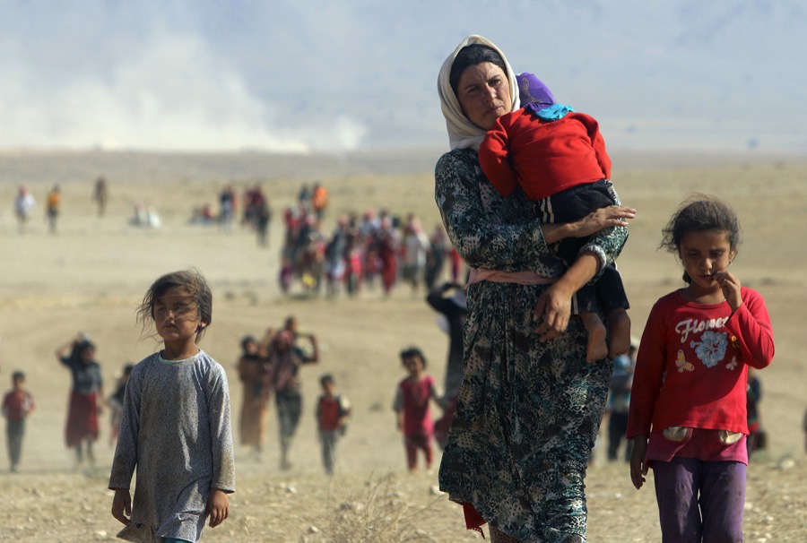 Displaced Yazidi people fleeing violence in Sinjar, walk toward the Syrian border on Aug. 11, 2014. Displaced Yazidi people fleeing violence in Sinjar, walk toward the Syrian border on Aug. 11, 2014.